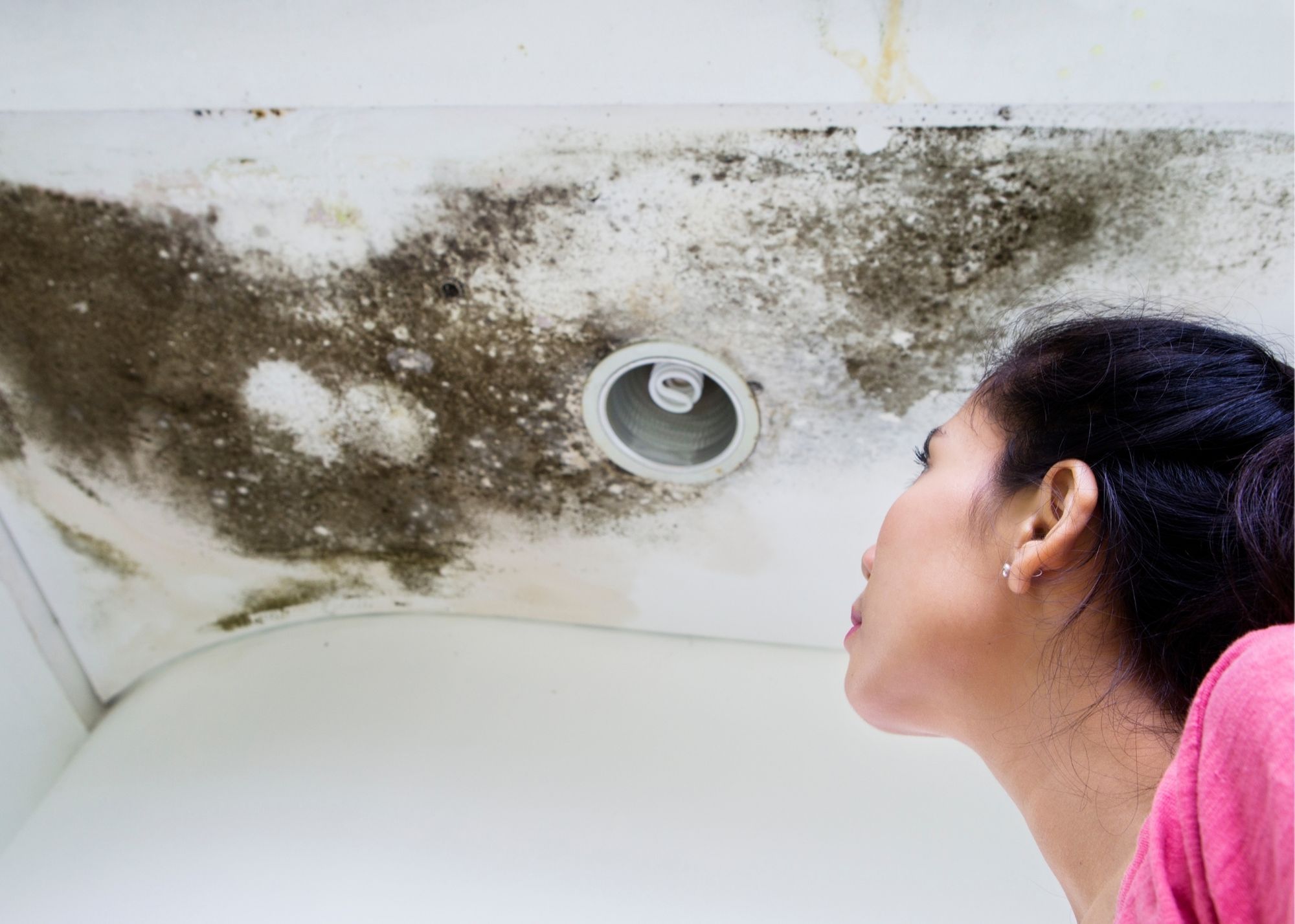 A technician inspecting a ceiling vent for mold in an Edgewater, FL home