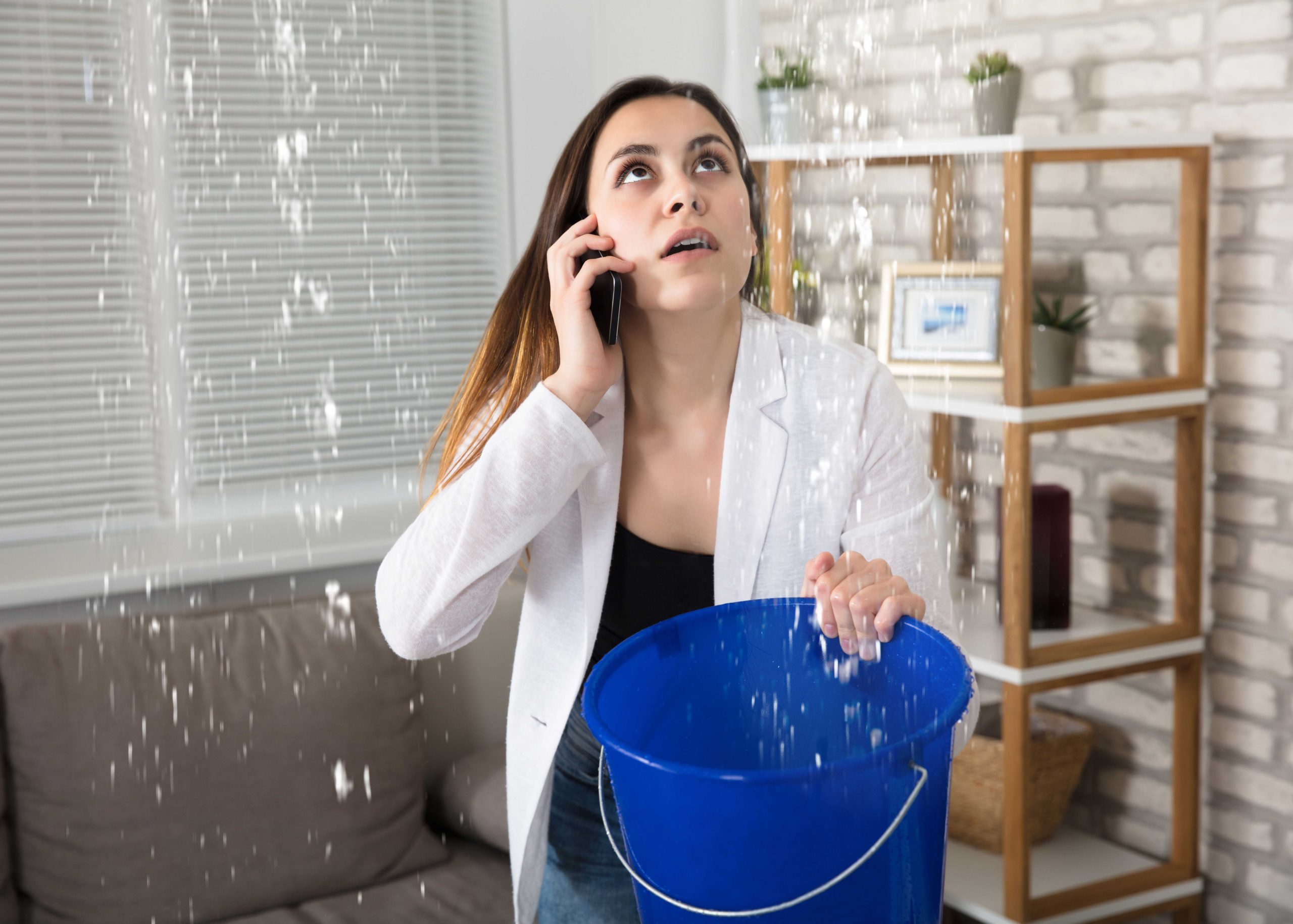 A bucket catching a ceiling leak inside an Edgewater, FL home