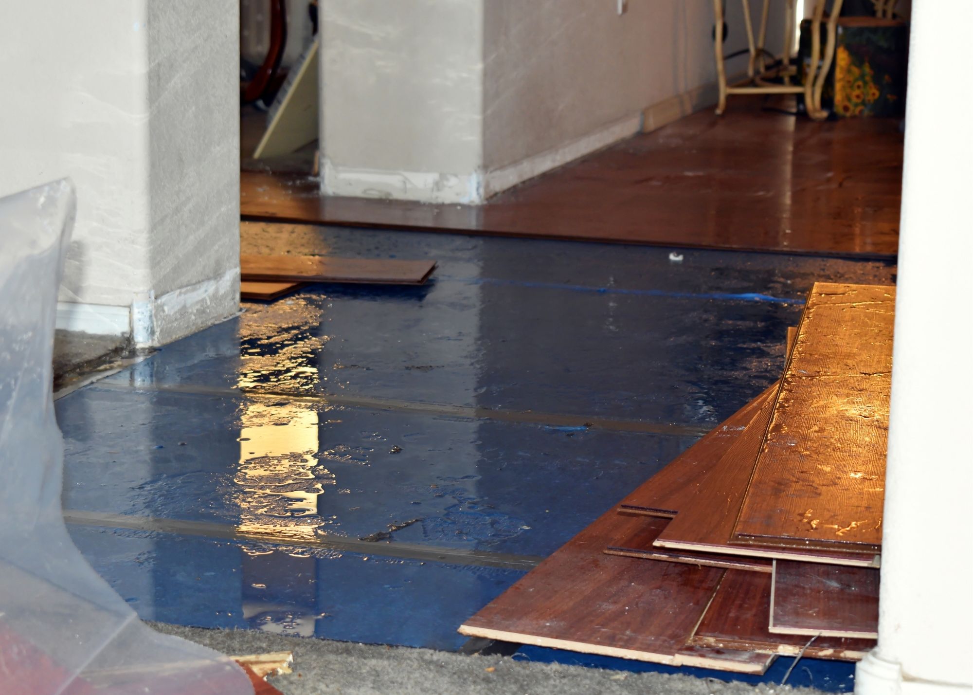 Water-damaged flooring being removed from a flooded lower-level room in an Edgewater, FL home